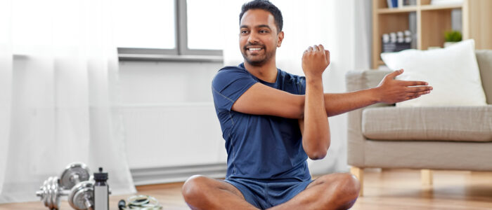 man training and stretching arm at home